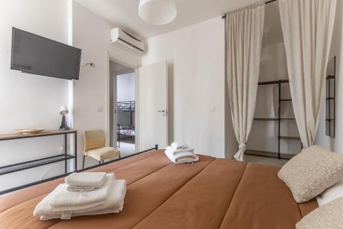 a bedroom with a large bed with towels on it at Maison de Sisine in Capurso