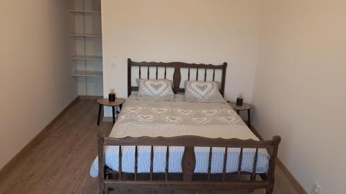 a bedroom with a wooden bed with pillows on it at Maison cosy esprit campagne in Luçon