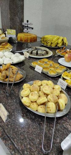 a buffet of different types of food on plates at Pousada Costa do Sol in Aracruz