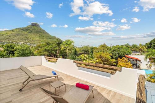 a balcony with a view of a mountain at Villa Marea - Exceptional Beachfront Sanctuary in Tamarin