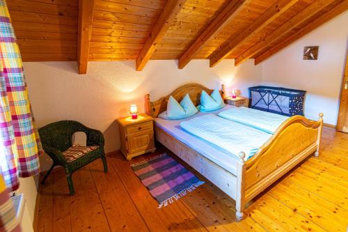a bedroom with a bed and a chair in a room at Ferienhaus Schachtenbach in Bayerisch Eisenstein