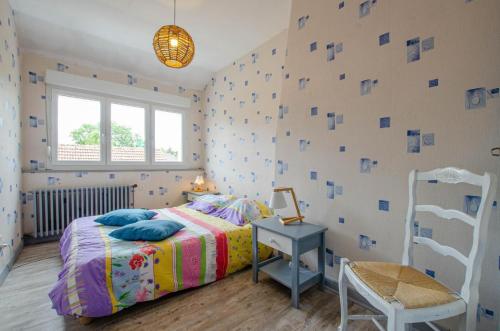 a bedroom with a bed and a chair at Entre seine et canal in Méry-sur-Seine