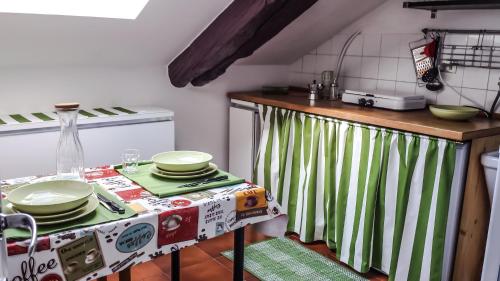 a kitchen with a table with green and white curtains at Cit Ma Bon in Turin
