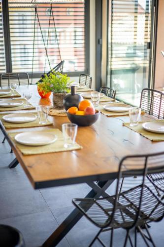 a long wooden table with a bowl of oranges on it at Magnifique Loft Rooftop et piscine 5 chambres 12 personnes in Bandol