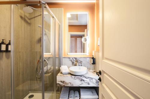 a bathroom with a sink and a glass shower at Viento Alacati Hotel in Alaçatı