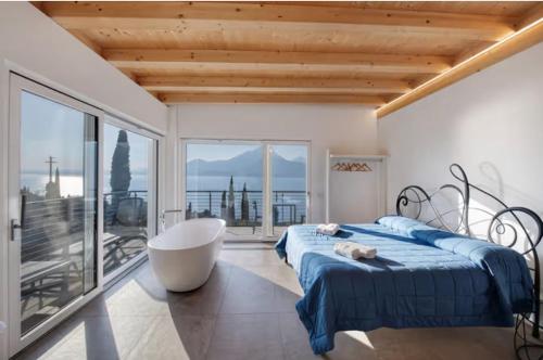 a bedroom with a bed and a tub and a balcony at Pai 521 openspace in Torri del Benaco