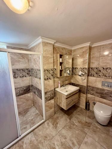 a bathroom with a shower and a sink and a toilet at Dove Apart Hotel in Fethiye