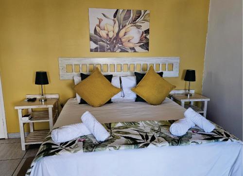a bedroom with a large bed with yellow walls at OCEAN VIEW GUEST HOUSE in Jeffreys Bay