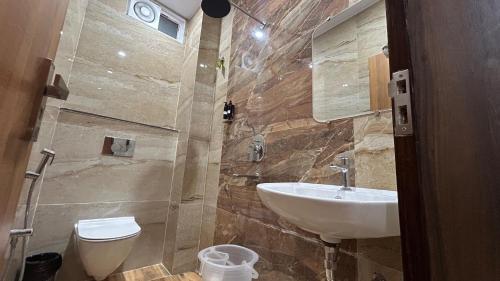 a bathroom with a sink and a toilet at Sanidhyam by Hotel Sahu near Temple in Varanasi