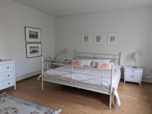 a bedroom with a white bed and two night stands at Ferienhaus Swanen Hus in Nordstrand