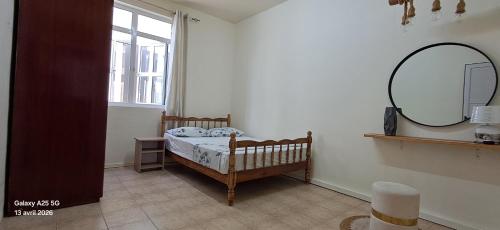 a small bedroom with a crib and a mirror at Life and memory in Blue Bay