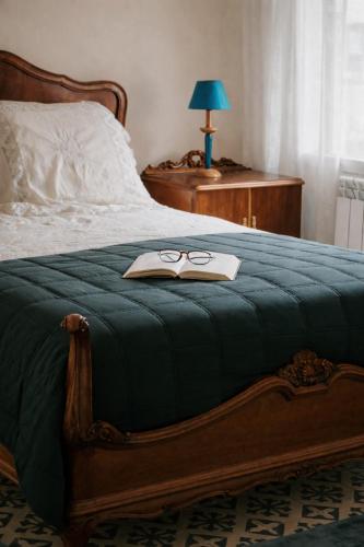 a bed with a book and pair of glasses on it at Alma de Barro in El Puente del Arzobispo