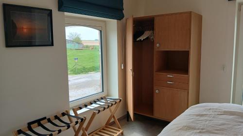 a bedroom with a window and a bed and a dresser at Gîte du Coupiat in Walcourt