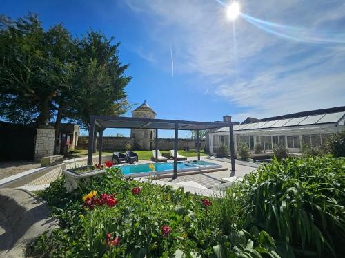 a garden with a swimming pool and a pavilion at Château de Naie in Avon-les-Roches
