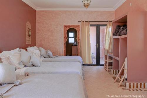 a bedroom with three beds and a room with shelves at Riad Belvedere in Ouzina