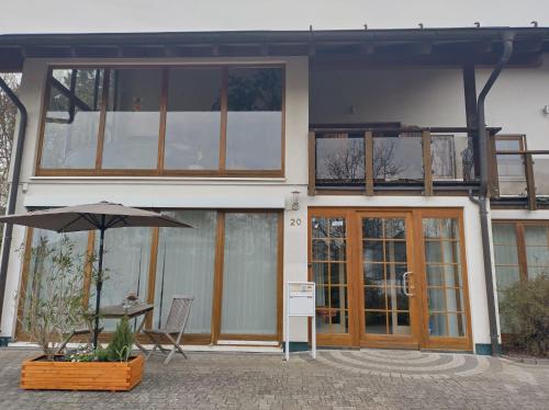 a building with a table and an umbrella in front of it at FeWo zum Der Hilderser in Hilders
