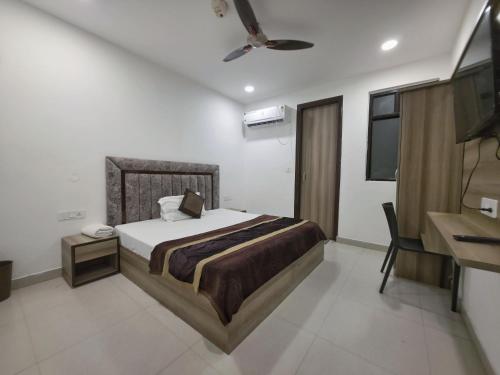 a bedroom with a bed and a desk in it at Hotel Hilson in New Delhi