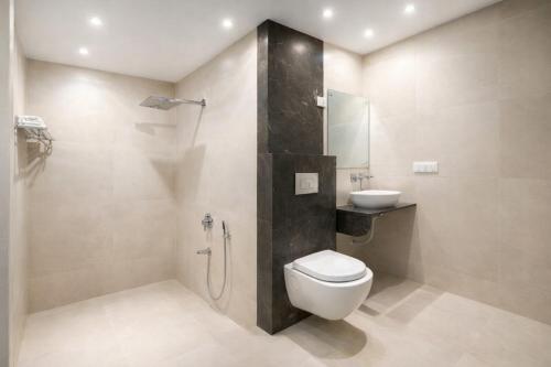 a bathroom with a shower and a toilet and a sink at OPO Horizon Aerocity ,Delhi Airport in Jāmb