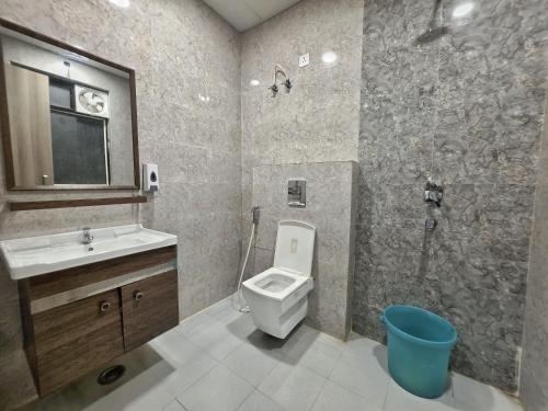 a bathroom with a toilet and a sink and a shower at Hotel Hilson in New Delhi