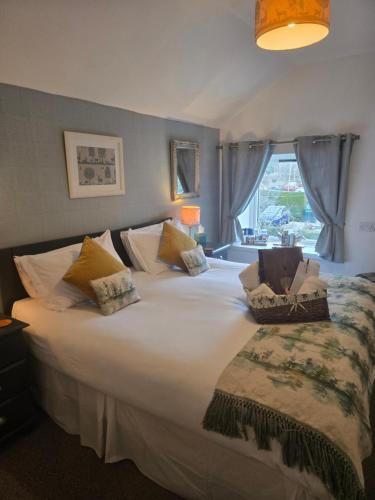 a bedroom with a large white bed with a window at Ardlogie Guest House in Aviemore