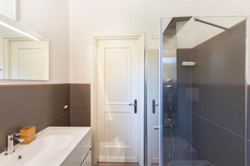 a bathroom with a sink and a glass shower at La Casa Del Tasso in Feriolo