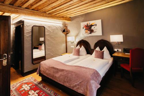 a bedroom with a large bed and a mirror at Altstadt Hotel Stadtkrug in Salzburg