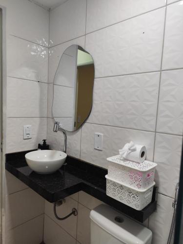 a bathroom with a sink and a mirror and a toilet at Haurea House in São Luís
