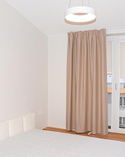a bedroom with a bed and a window at Prie jūros in Melnragė