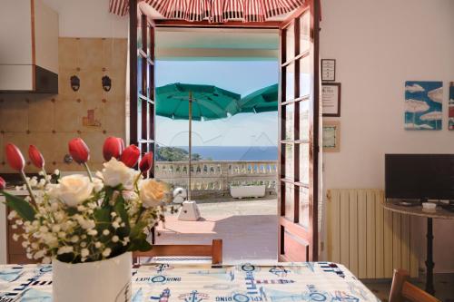 a vase of flowers on a table with a view of the ocean at Villa Flora - Goelba in Capoliveri