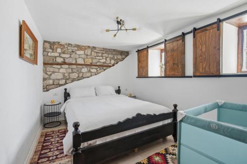 a bedroom with a bed and some windows at Villa Kokoshi, an extraordinary experience. in Berat
