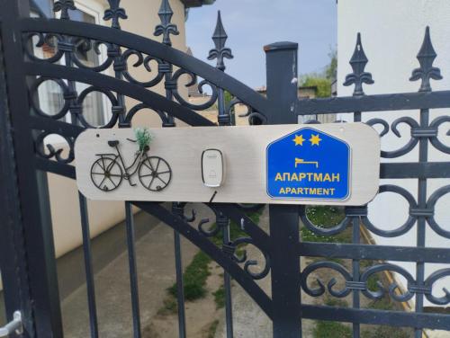 a sign on a gate with a bike on it at Cyclo Apartment Pinki in Bačka Palanka