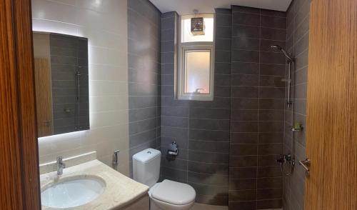 a bathroom with a sink and a toilet and a shower at The Saj Hotel Apartments in Ras al Khaimah