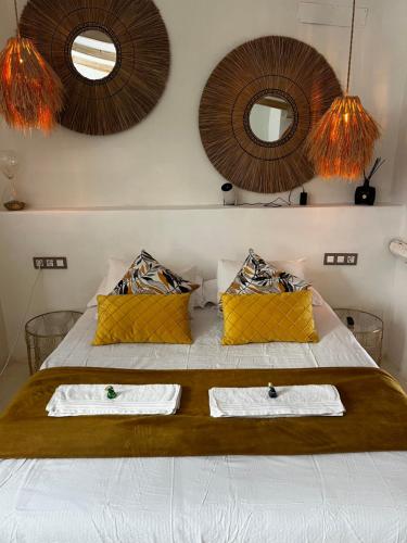 a bedroom with a bed with two towels and two mirrors at Tu Casita Rural in Valdilecha