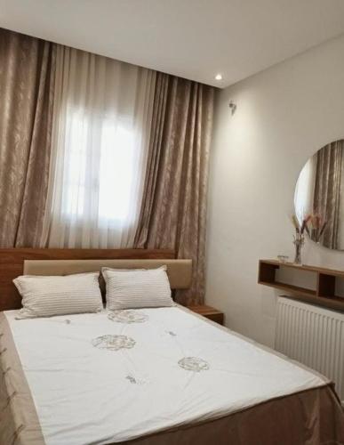 a bedroom with a large white bed with a window at Dar Haroun Tunis in Tunis