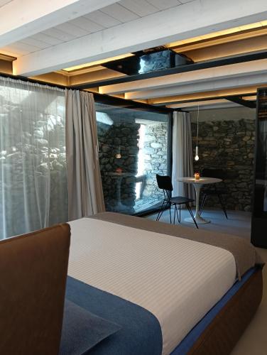 a bedroom with a bed and a stone wall at V&V RentRoom Design in Gignod