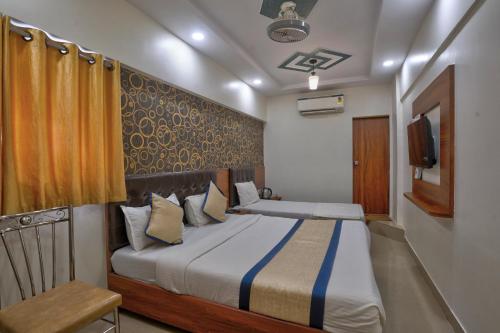 a bedroom with a bed and a television in it at Hotel Saineel Residency in Mumbai