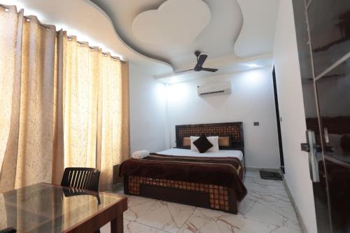 a bedroom with a bed and a table and a window at The Redcarmine in New Delhi