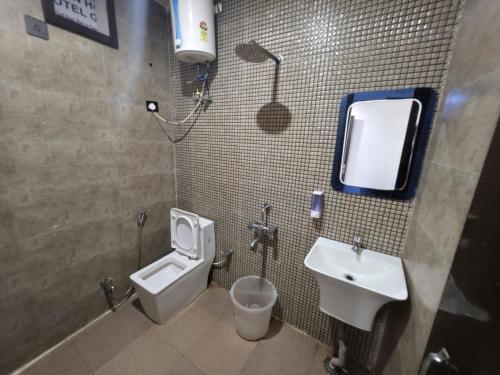 a bathroom with a toilet and a bidet and a sink at The Redcarmine in New Delhi