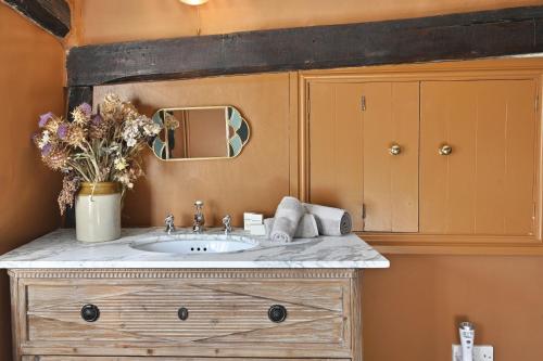 a bathroom with a sink and a mirror at Blackham Farm in Hartfield