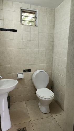 a bathroom with a toilet and a sink at INDIRA Hospedaje Canning in Canning