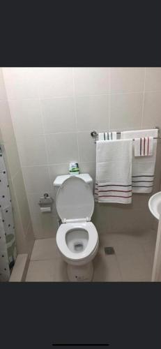 a bathroom with a toilet and a sink and towels at SMDC Tagaytay Condominium in Kaybagal