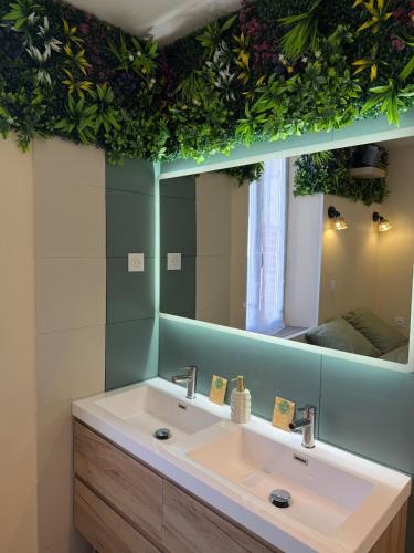 a bathroom with a sink and a large mirror at La Jungle - A71 - Jacuzzi et Cinéma in La Chapelle-Saint-Ursin