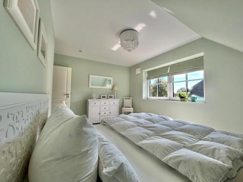 a bedroom with a large bed with white pillows at Reetdachhaus Nordstern in Garding