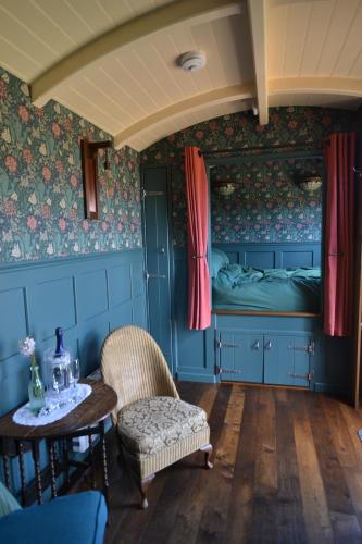 a room with a bed and a table and chairs at Charlotte-Rose Shepherd's Hut in Hethersett