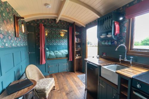 a kitchen with blue cabinets and a sink at Charlotte-Rose Shepherd's Hut in Hethersett