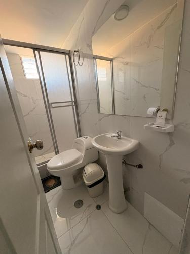 a white bathroom with a sink and a toilet at Hotel Altara AQP in Arequipa