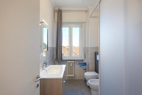 a bathroom with a sink and a toilet and a window at Lexia Suite in Lesa