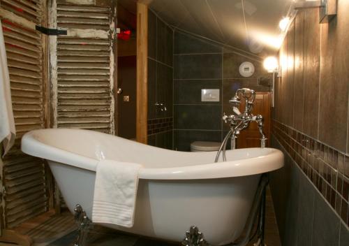 a bathroom with a bath tub and a sink at Ô Délices de la Monnerie in Bourgnac