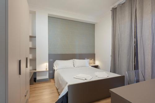 a bedroom with a white bed and a desk at Lexia Suite in Lesa