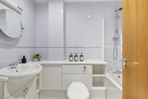 a white bathroom with a sink and a shower at High Quays Apartments - Properties Unique in Newcastle upon Tyne